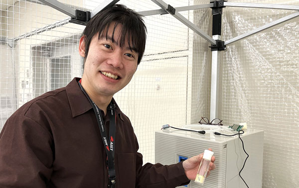 細胞機能解析研究グループ　塩田裕介 主任研究員が実験室で微笑んでいる姿