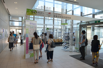 会場入口で案内パネルを確認する来場者たち