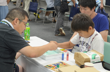 実験材料を前に子どもに手順を説明する研究者の様子