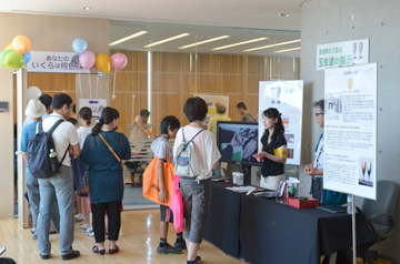 展示ブースの前で説明を聞く来場者たち