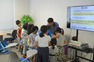 研究者の周りに集まり、説明を熱心に聞く子どもたち