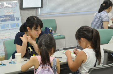 大人の説明を聞きながら工作に取り組む子どもたち