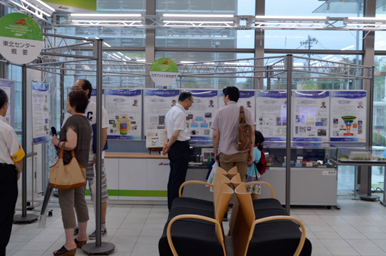 ロビーの展示パネルを来場者が見学している様子