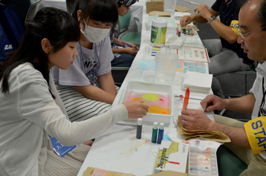 ろ紙にインクを落として色が広がる様子を観察しながら、参加者がクロマトグラフィーの工作を進めている様子