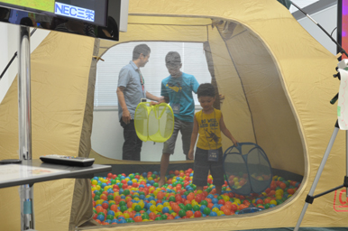 テントの中のボールプールで、子どもが遊び、スタッフがそばで見守っている様子