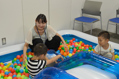 室内のボールプールで、子どもたちが遊び、大人がそばで見守っている様子