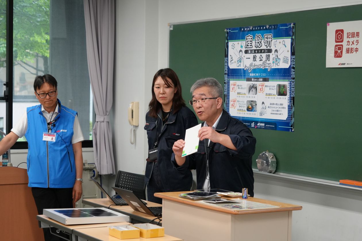 講師が太陽電池のサンプルを示しながら、参加者に説明している様子